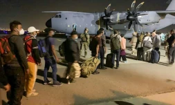 Des personnes attendent pour embarquer à bord d'un avion militaire français sur le tarmac de l'aéroport de Kaboul, le 17 août 2021