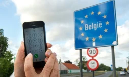 Un homme montre son téléphone portable à la frontière belge