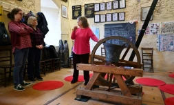 Kate Flavell (d), secrétaire des sonneurs de cloches de l'église de Tous-les-Saints, explique à Charlotte Mafi (2e g) et Anne Porter (2e d) les règles de sécurité, le 25 mars 2023 à Kinston-upon-Thames, près de Londres