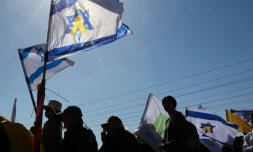 Des Israéliens attendant le passage du convoi funéraire de la famille Bibas, dans le kibboutz Nir Oz le 26 février 2025