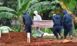 Des fossoyeurs portent le cercueil d'une personne décédée du coronavirus au cimetiÚre de Pondok Ranggon, le 6 mai 2020 à Jakarta, en Indonésie
