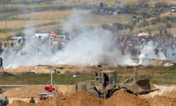 Les soldats israéliens tirent des gaz lacrymogÚnes sur des manifestants palestiniens le long de la barriÚre de sécurité séparant la bande de Gaza d'Israël, le 6 avril 2018