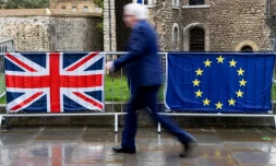 Un Londonien passe devant les drapeaux du Royaume-Uni et de l'Union européenne, près du parlement britannique, le 18 mars 2019