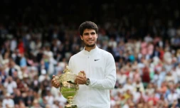 L'Espagnol Carlos Alcaraz brandit le trophée du vainqueur de Wimbledon, après avoir battu le Serbe Novak Djokovic en finale du simple messieurs, le 16 juillet 2023, à Londres.