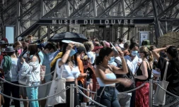 Des visiteurs devant l'entrée du Louvre le 6 août 2020 à Paris