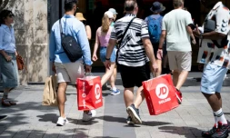 Des passants portent des sacs de courses à Paris, le 25 juin 2025, premier jour des soldes d'été en France