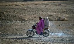 Une femme en burqa assise derrière un homme en moto dans le district d?Arghandab, dans le sud de l?Afghanistan, le 22 février 2021