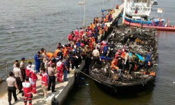 Des sauveteurs indonésiens près du bateau qui transportait environ 200 personnes au large de la côte de Jakarta à l'île de Tidung et qui a pris feu faisant 23 morts et 17 disparus, le 1er janvier 2017