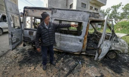 Un Palestinien à proximité d'un véhicule calciné aprÚs une attaque attribuée à des colons israéliens à Jalud, prÚs de Naplouse, en Cisjordanie occupée, le 22 mars 2026