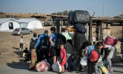 Des migrants attendent pour être dirigés vers  un nouveau campement de réfugiés après l'incendie du camp de Moria, sur l'ile de Lesbos, le 12 septembre 2020
