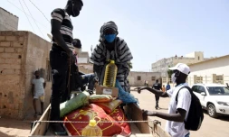 Des bénéficiaires d'une vaste distribution d'aide alimentaire au Sénégal chargent leurs rations sur une carriole dans un faubourg de Dakar au lancement de l'opération le 28 avril 2020