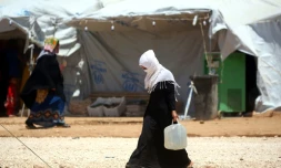 Une Syrienne qui a fui les combats à Raqa porte un bidon d'eau, le 9 juin 2017 à Ras al-Ain