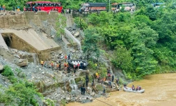 Des équipes de secours recherchent des survivants dans la rivière Trishuli après un glissement de terrain qui a emporté deux bus, le 12 juillet 2024 à Simaltar, au Népal