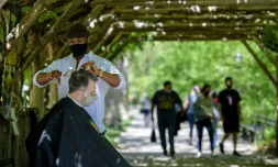 Le coiffeur de Central Park, Herman James, coupe les cheveux d'un client Ă Central Park, Ă New York, le 6 mai 2021