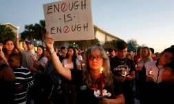 Une manifestante brandit une pancarte clamant "Assez c'est assez !" lors d'une veillée pour les victimes de la fusillade du lycée à Parkland qui a coûté la vie à 17 personnes 