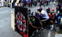 Des opposants au régime de Nicolas Maduro se protègent des assauts de la police derrière des boucliers de fortune, le 22 juillet 2017 à Caracas