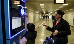 Un enfant turc et sa mère recyclent des bouteilles en plastique pour créditer leur carte de transport à Istanbul, le 9 novembre 2018