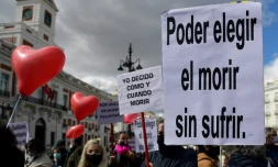 Des personnes tiennent des pancartes sur lesquelles on peut lire "Pouvoir choisir de mourir sans souffrir" et "Je décide quand et comment mourir", lors d'une manifestation en faveur d'une loi légalisant l'euthanasie à Madrid, le 18 mars 2021