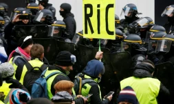 Une pancarte réclamant l'instauration d'un référendum d'initiative citoyenne (RIC) est brandie lors d'une manifestation de "gilets jaunes" à Paris, le 15 décembre 2018