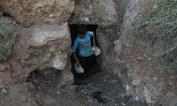 Un enfant transporte des pierres durant des travaux de construction d'un abri souterrain, dans la province syrienne d'Idleb, le 15 septembre 2018