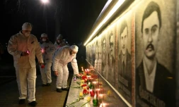 Des employĂ©s de la centrale de Tchernobyl allument des bougies et dĂ©posent des fleurs devant le monument Ă la mĂ©moire des victimes de la catastrophe, Ă Slavutych, la ville oĂč le personnel du site vivait, Ă 50 km du site, le 25 avril 2021