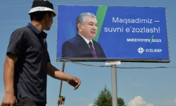 Un homme passe à côté d'une affiche de campagne du président de l'Ouzbékistan Chavkat Mirzioïev, à la veille d'un scrutin anticipé, non loin de la capitale Tachkent, le 8 juillet 2023