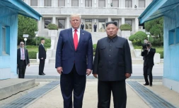 Photo fournie le 1er juillet 2019 par l'agence nord-coréenne Kcna du dirigeant nord-coréen Kim Jong Un (d) et le président américain Donald Trump se tenant au nord de la ligne de démarcation entre les deux Corées, le 30 juin 2019 à Panmunjom