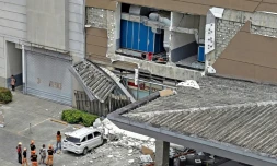 Les autorités inspectent un mur endommagé à l'extérieur d'un centre commercial à Butuan, sur l'île méridionale de Mindanao, le 10 octobre 2025, après un séisme qui a frappé le sud des Philippines