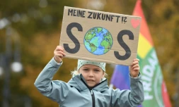 Une petite fille participant à la manifestation pour le climat à Berlin tient une pancart où est inscrit "Mon avenir ?! SOS", le 22 octobre 2021