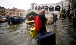 Un homme et ses valises près du po,t Rialto le 15 novembre 2019 à Venise