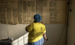 Une sympathisante du CongrÚs national africain (ANC) regarde une liste de noms pour une réunion de campagne à Philipstown, le 22 mai 2024 en Afrique du Sud