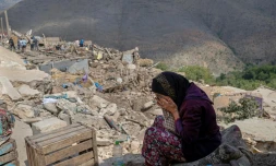 Photo prise le 12 septembre 2023 dans le village de Imi N'Talat, dans le centre du Maroc, montrant une femme pleurant devant les décombres d'une maison aprÚs un puissant séisme