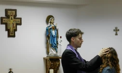 Le prêtre Francisco Marques appose ses mains sur la tête d'une femme lors d'une séance d'exorcisme, le 30 mai 2026 à Fatima, au Portugal