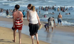 Des touristes se promènent sur la plage de Mount Lavinia, sud de Colombo, le 3 juillet 2016