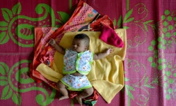 Un bébé dort sur une natte dans un camp d'Aluva, près de Cochin, au Kerala le 20 août 2018