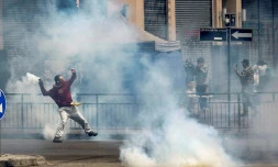 Un manifestant renvoie une grenade lacrymogĂšne vers les forces de l'ordre, lors de manifestations le 19 octobre 2019 Ă Santiago du Chili