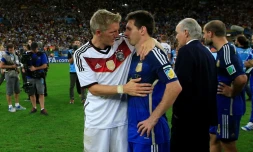 L'attaquant vedette de l'Argentine Lionel Messi consolé par le milieu de terrain allemand Bastian Schweinsteiger après la victoire de l'Allemagne en finale du Mondial, le 13 juin 2014 à Rio