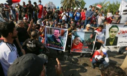Des manifestants irakiens brandissent les portraits de leurs camarades tués, sur la place Tahrir à Bagdad, le 2 novembre 2019