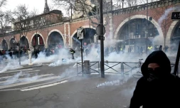 Des manifestants dans des nuages de gaz lacrymogène lors de la manifestation parisienne contre la réforme des retraites, le 11 janvier 2020