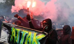 Des manifestants vĂȘtus de noir et cagoulĂ©s, Ă la maniĂšre des "black blocs", dĂ©filent lors du 1er mai 2018 Ă Paris