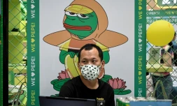 Un homme est assis devant une affiche de Pepe the Frog, symbole de la désillusion de la jeunesse chinoise, dans un centre commercial de Pékin, le 29 mai 2021