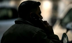 Un détective de terrain parle sur son téléphone portable avant de partir en mission, à New Delhi le 9 décembre 2024