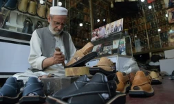 Le chausseur Chacha Noor Din fabrique des "chappals", sandale traditionnelle au Pakistan, le 1er avril Ă Peshawar