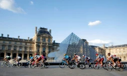 Le peloton passant devant la pyramide du Louvres à Paris lors de la dernière étape du Tour de France 2019  entre Rambouillet et les Champs Elysées, le 28 juillet.