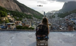Une touriste se fait filmer par un drone sur le toit d'une maison dans la favela de Rocinha, à Rio de Janeiro, au Brésil, le 5 mars 2026