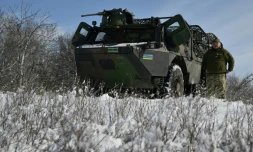 Le chauffeur militaire ukrainien Moroz, de la 24e brigade mécanisée, à côté de son véhicule blindé de transport de troupes (VAB) de fabrication française, lors d'un entraînement dans la région de Donetsk, le 16 février 2025 en Ukraine