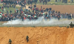 Des manifestants palestiniens et des soldats israéliens se font face à la frontiÚre de la bande de Gaza, le 30 mars 2018