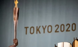 Un relayeur tient le flambeau olympique lors de la cérémonie d&rsquo;allumage de la flamme olympique au premier jour du relais à Machida, à l'ouest de Tokyo, le 9 juillet 2021