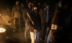 Des riverains organisés en groupe de protection contre les pillards, armés de fusils et de machettes, à un poste de contrôle à l'entrée du township de Phoenix, à Durban, en Afrique du Sud, le 15 juillet 2021.