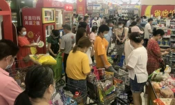 Das habitants de la ville chinoise de Wuhan font des achats dans un supermarché le 2 août 2021 